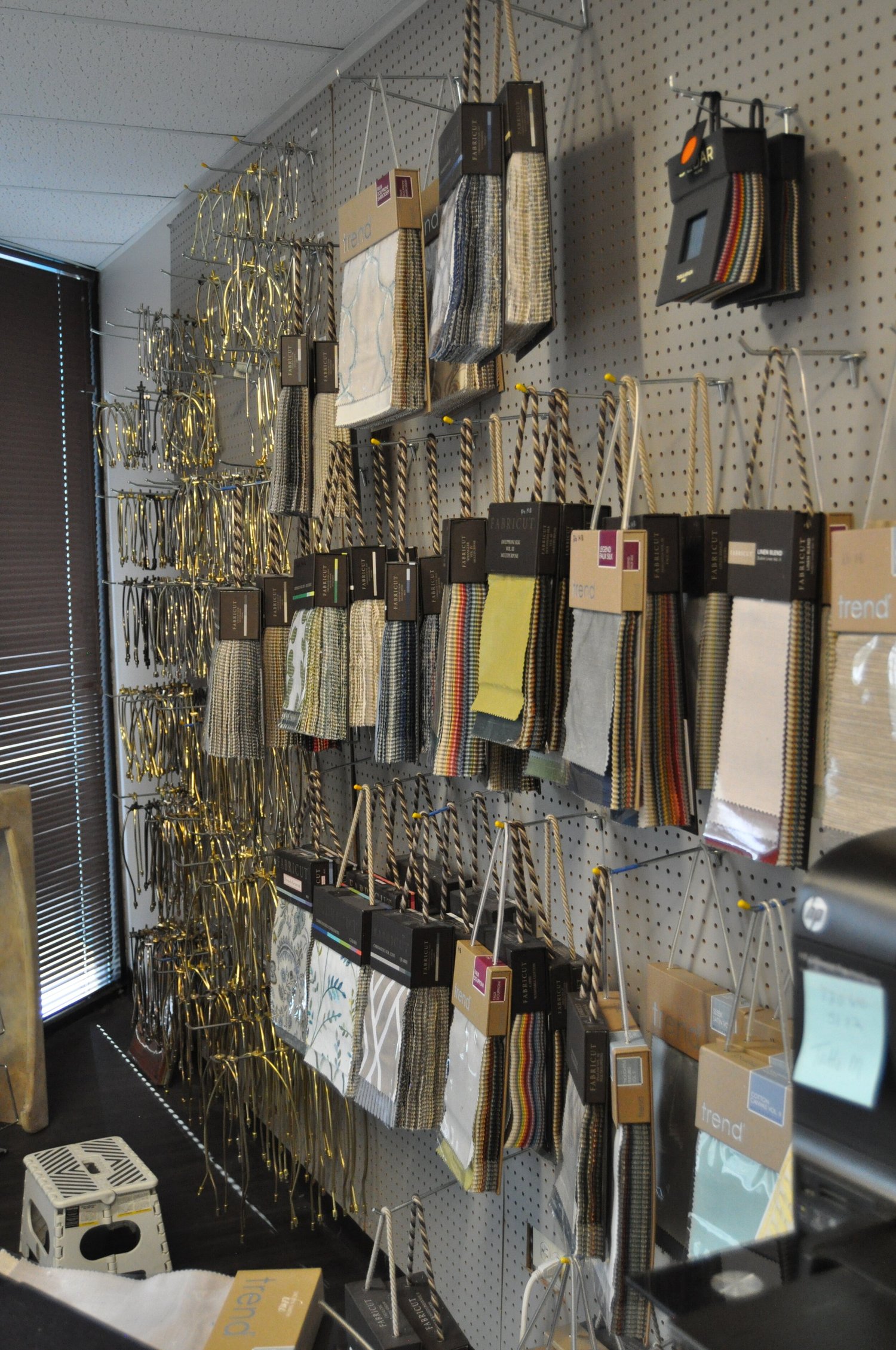 Shelves of shade fabrics and materials along a workroom wall