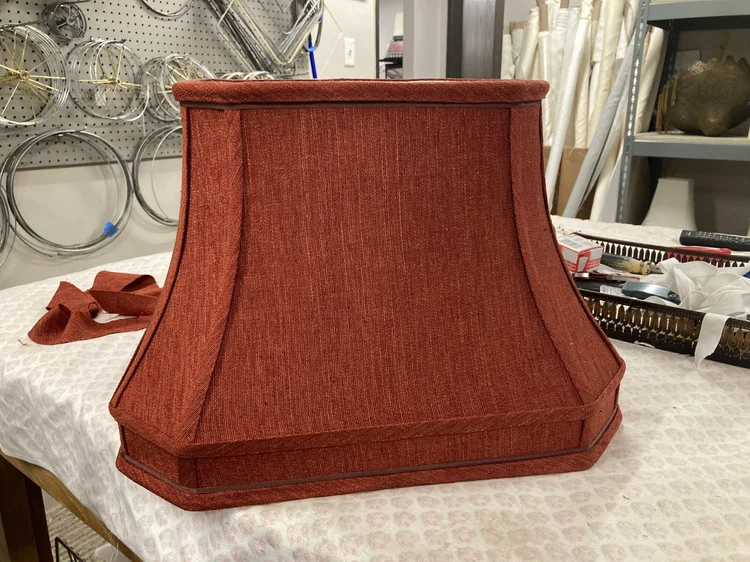 Tailored rust-red square lampshade in the atelier