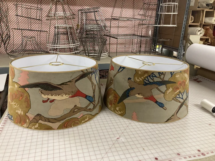 Pair of custom bird-print drum lampshades on the worktable